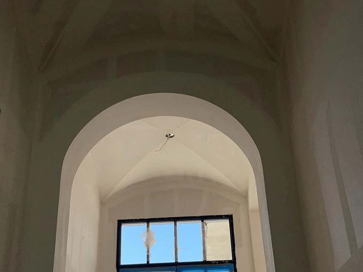 Tall arched window wall taped and ready
