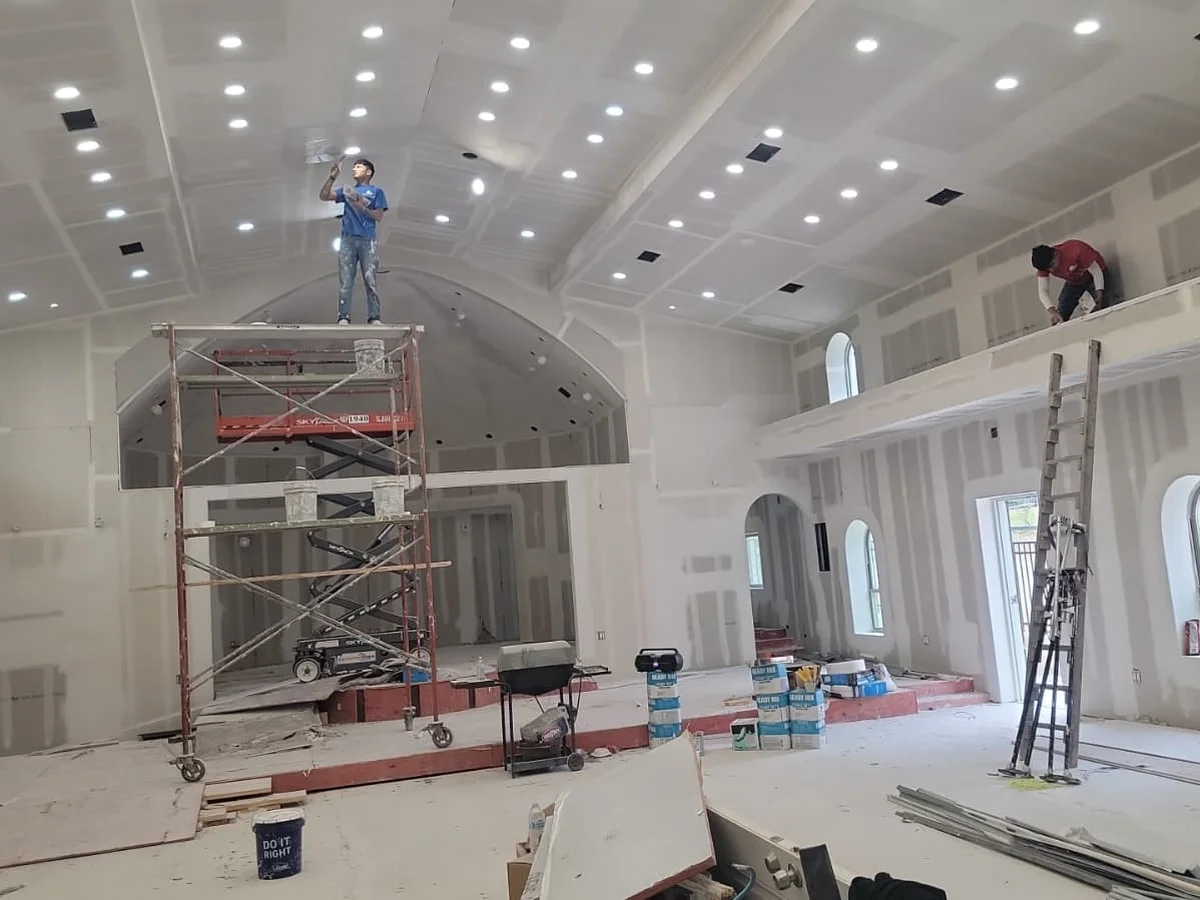 Church hall with arches, crew finishing on scaffold